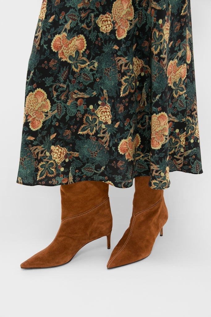 Espresso Malva 60 Booties: Classic, pointed-toe brown suede ankle boots with thin heels, exuding effortless elegance and high-end style, paired with a dark floral skirt.