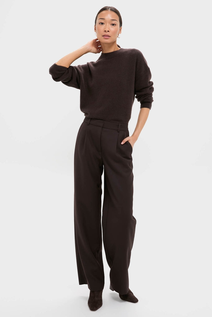 Woman models Deep Brown Trent Trouser with classic wide-leg design, effortlessly styled with knit sweater, showcasing high-end, fun, and versatile fashion for confident, everyday wear.