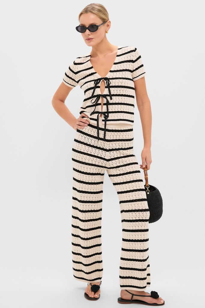 Model wearing a classic, effortless knit ensemble with Black Flor Rose Wrap Sandals, exuding fun and high-end style, perfect for Tuckernuck’s cool, confident vibe.