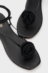 Black Flor Rose Wrap Sandals featuring classic thong design with a braided rose detail over the toe post and an effortless ankle strap, offering a fun, high-end look.