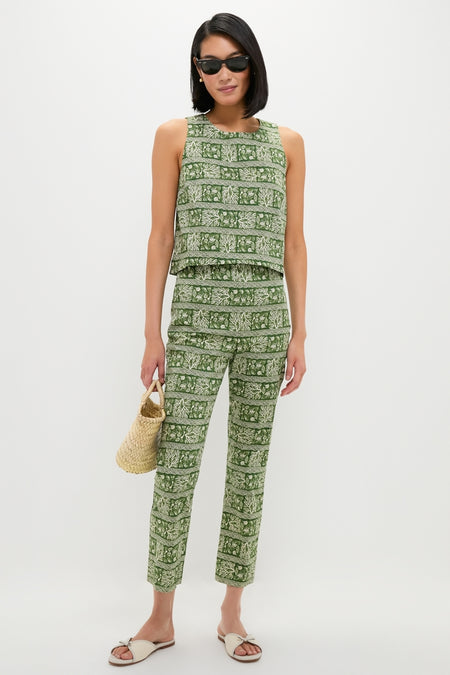 Model wearing Off White Gianna Flat Sandals; classic slide-ons with bow detail, perfect for effortless, fun strolls. Paired with a botanical print outfit and straw tote.