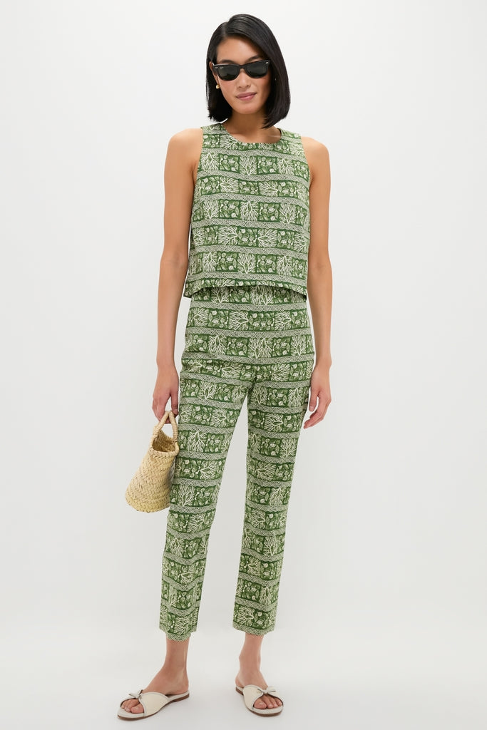 Model wearing Off White Gianna Flat Sandals; classic slide-ons with bow detail, perfect for effortless, fun strolls. Paired with a botanical print outfit and straw tote.