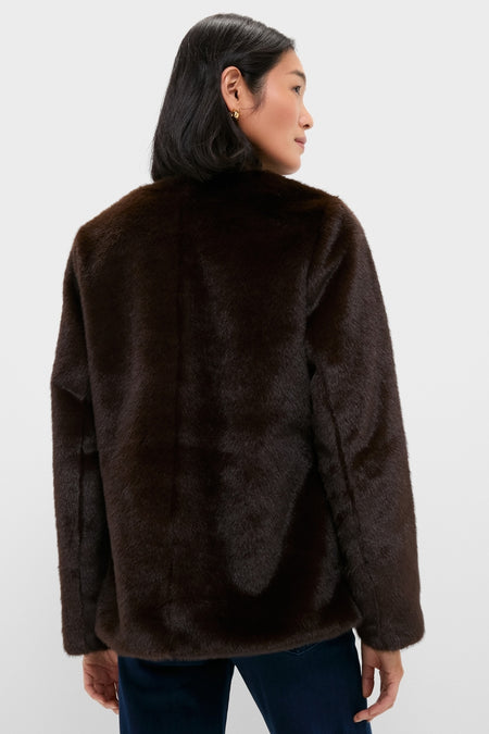 Woman wearing classic Dark Brown Cassidy Faux Fur Jacket; an effortless, high-end layer with front closures, perfect for winter, styled with dark blue jeans.