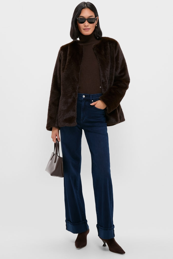 Model wearing the classic Dark Brown Cassidy Faux Fur Jacket, styled effortlessly with high-end wide-leg jeans and chic accessories, embodying fun and sophisticated winter fashion.
