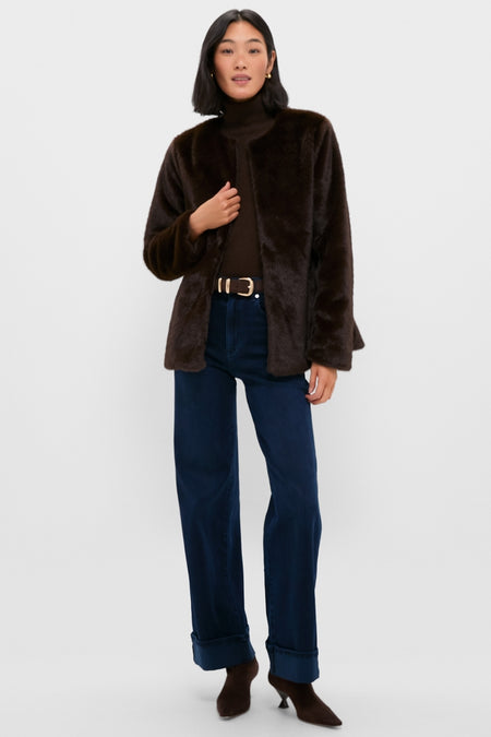 Model wears the classic Dark Brown Cassidy Faux Fur Jacket, effortlessly styled open over a turtleneck and jeans, embodying a fun, high-end winter look.