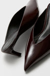 Maplewood Loren Mid Heels in glossy patent leather offer a classic, effortless style with pointed toes and slender heels, perfect for a fun, high-end look.