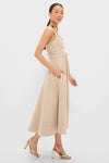 Woman models the classic Dune Suede Kendra Maxi Dress, featuring an effortless sleeveless design, fitted bodice, flared skirt, self-tie belt, and discreet side pockets.