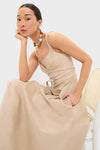 Young woman in a classic, high-end Dune Suede Kendra Maxi Dress, featuring an effortless wrap-style waist tie and fun side pockets, exuding confidence and elegance.
