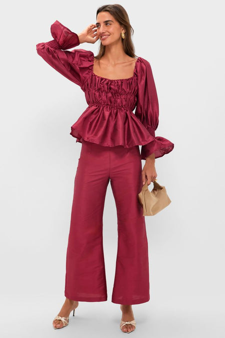 Woman in classic burgundy two-piece outfit, showcasing Platina Renee Mules with strappy upper and kitten heel. She exudes effortless, high-end style with fun, elegant accessories.