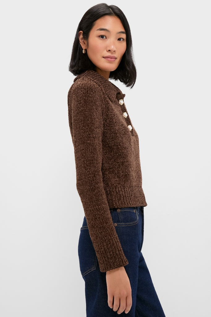 Young person in profile wearing the Brown Fraser Sweater, a classic, textured knit with decorative buttons, embodying effortless style paired with dark blue jeans.