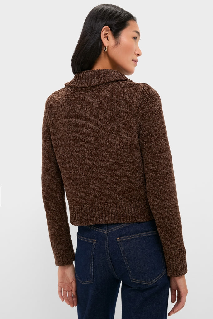 Person wearing a classic, dark brown Fraser Sweater with a wide collar and long sleeves, paired with dark blue jeans, embodying effortless, high-end style.