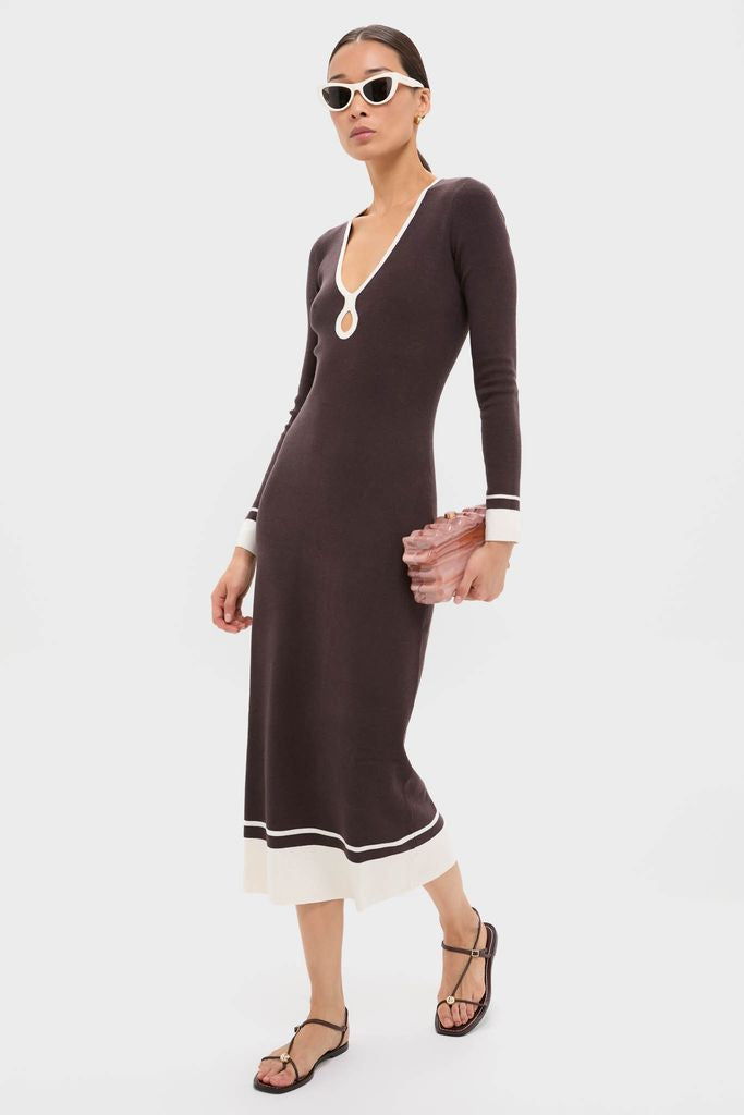 Woman in Espresso Egret Long Sleeve Ribbed Maxi Dress with keyhole neckline, white trim, and gold hoop earrings, holding a sculptural clutch, embodying classic, effortless, high-end style.