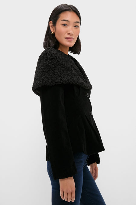 Woman in classic Black Geneva Jacket with textured cape collar and gold hoops, embodying effortless, high-end style with fun, versatile elements.