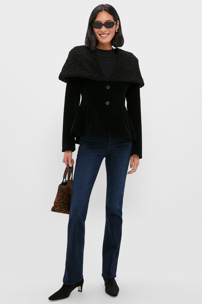 Woman in a classic Black Geneva Jacket with a textured shawl collar, styled effortlessly with dark-wash jeans, ankle boots, and a leopard-print tote, embodying high-end, fun fashion.
