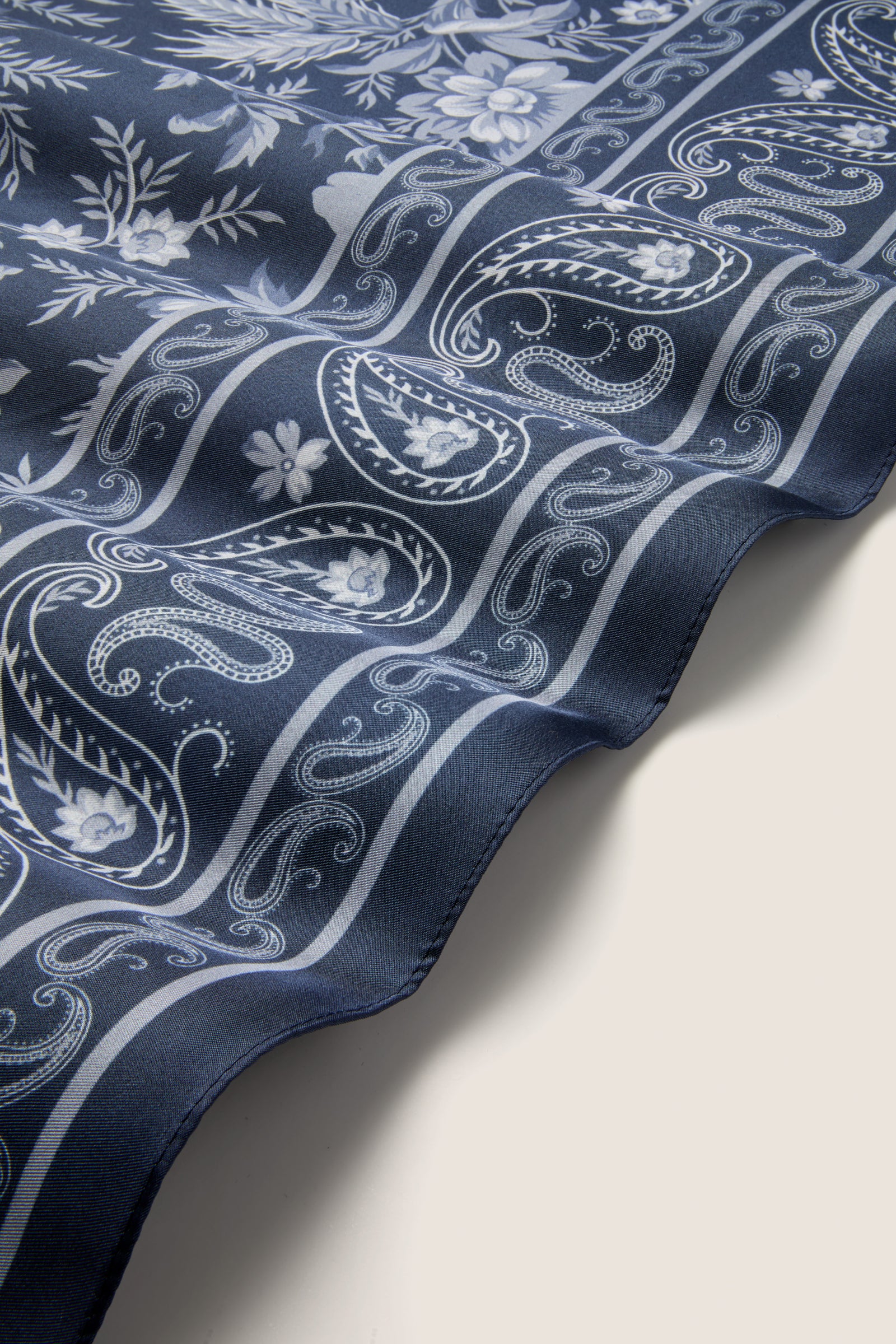 Navy Floral Bandana Medium Silk Scarf, featuring classic white paisley and floral motifs. An effortless, high-end accessory for versatile styling and fun fashion elevation.