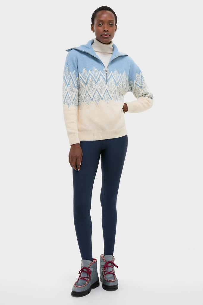 Ashley Blue Hedda Fairisle Half Zip sweater, featuring a classic zigzag pattern, layered over a white turtleneck, paired with navy leggings and gray hiking boots for an effortless, high-end look.