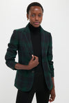 Person wearing the classic Green Navy Multi Tartan Brushed Wool Blazer over a black turtleneck, exuding an effortlessly cool and high-end style.