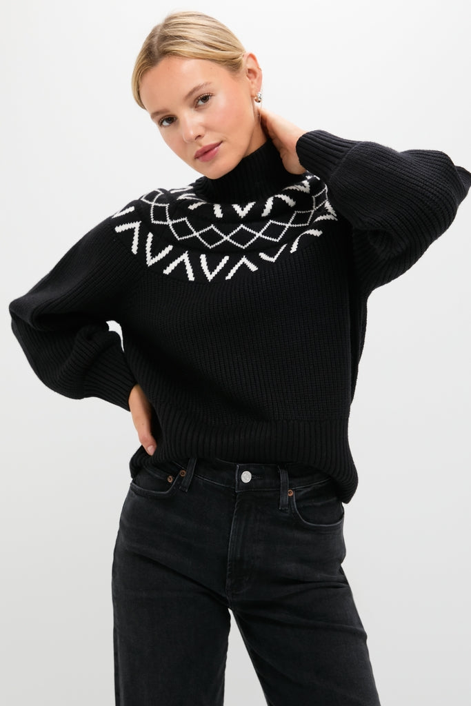 Young woman models the Black Marcie Fairisle Yoke Knit sweater, effortlessly pairing its classic turtleneck and balloon sleeves with dark jeans for a fun, high-end look.