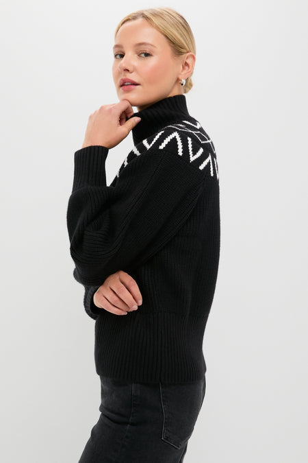 Model in profile wearing the classic Black Marcie Fairisle Yoke Knit sweater, featuring a chunky turtleneck, balloon sleeves, and chic geometric pattern, paired with dark jeans.
