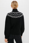 Back view of a woman in a classic Black Marcie Fairisle Yoke Knit, showcasing its effortless design with fun geometric patterns, balloon sleeves, and a relaxed fit.