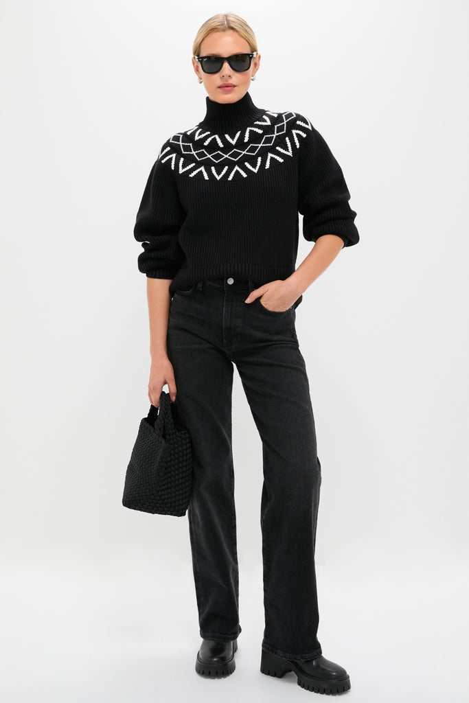 Woman in classic Black Marcie Fairisle Yoke Knit sweater, styled effortlessly with straight-leg jeans and platform boots, embodies high-end winter fashion with a fun geometric pattern.