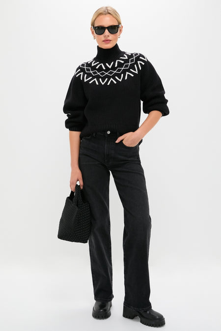 Woman in classic Black Marcie Fairisle Yoke Knit sweater, styled effortlessly with straight-leg jeans and platform boots, embodies high-end winter fashion with a fun geometric pattern.
