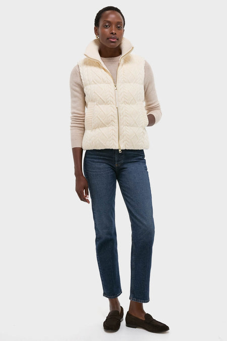 Woman models the Egret Irina Cable Knit Gilet, featuring a classic rib-knit collar and cable design. This effortless, high-end piece pairs fun style with practicality.