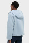 Person in classic Ashley Blue Rosia Fleece Hoodie, featuring a quilted back, large hood, and boxy fit, embodying effortless, high-end style with leggings.