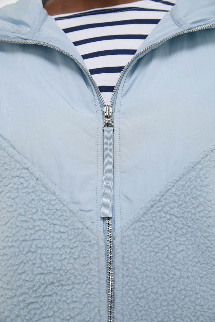 Ashley Blue Rosia Fleece Hoodie features a classic design with a smooth nylon upper and plush sherpa fleece lower, offering an effortless, fun, high-end look.