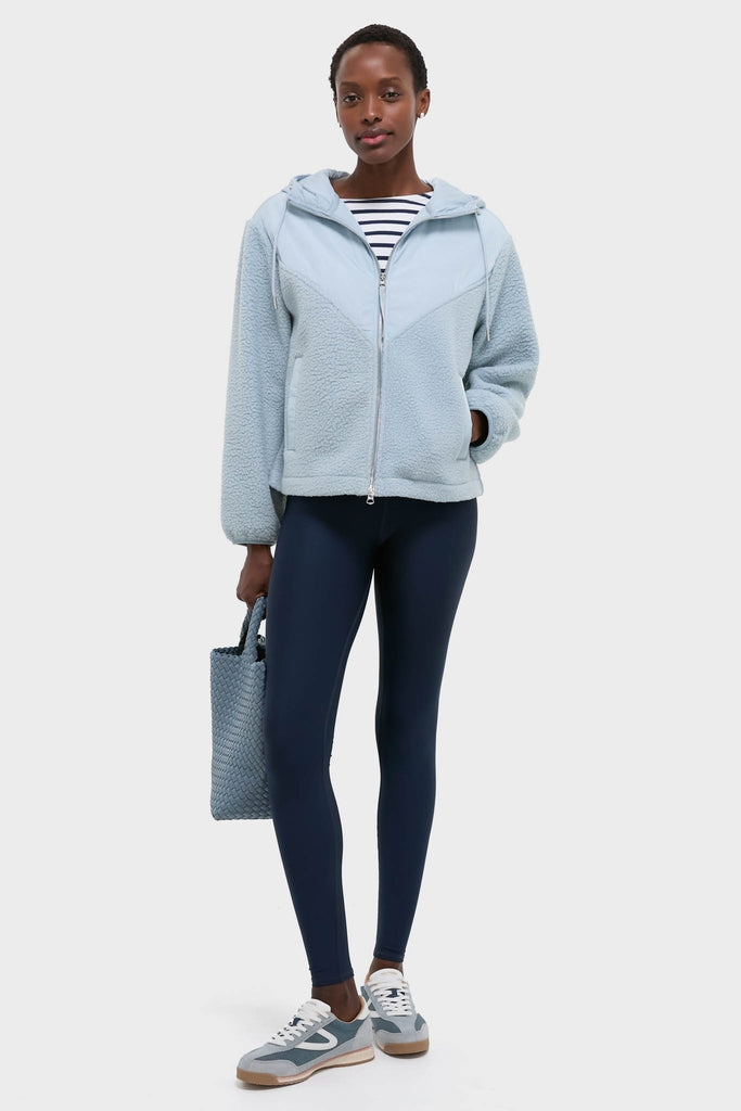 Woman wearing the Ashley Blue Rosia Fleece Hoodie with classic striped top, navy leggings, and light sneakers, carrying a woven tote, exuding effortless, high-end style.
