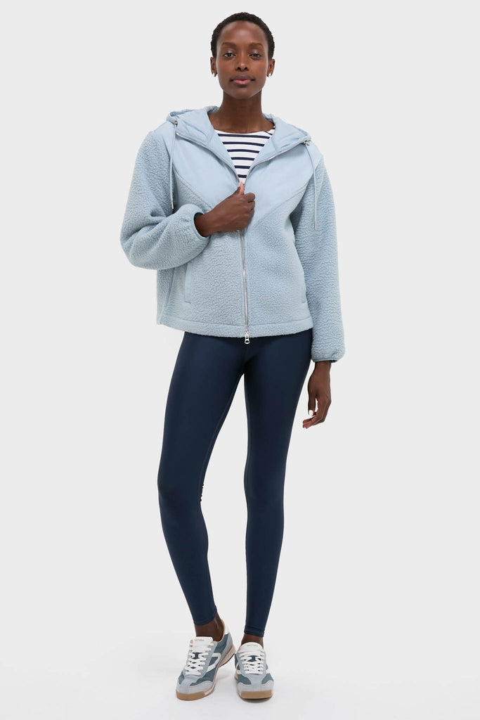 Model in classic Ashley Blue Rosia Fleece Hoodie with hood, showcasing effortless style. Paired with navy leggings and athletic sneakers, perfect for a fun, high-end casual look.