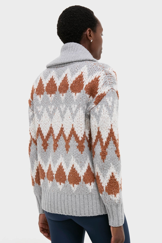 Person in classic Grey Melange Brockley Jacquard Knit Jacket with rust-brown motifs, shawl collar, and ribbed details, creating an effortless, high-end look.