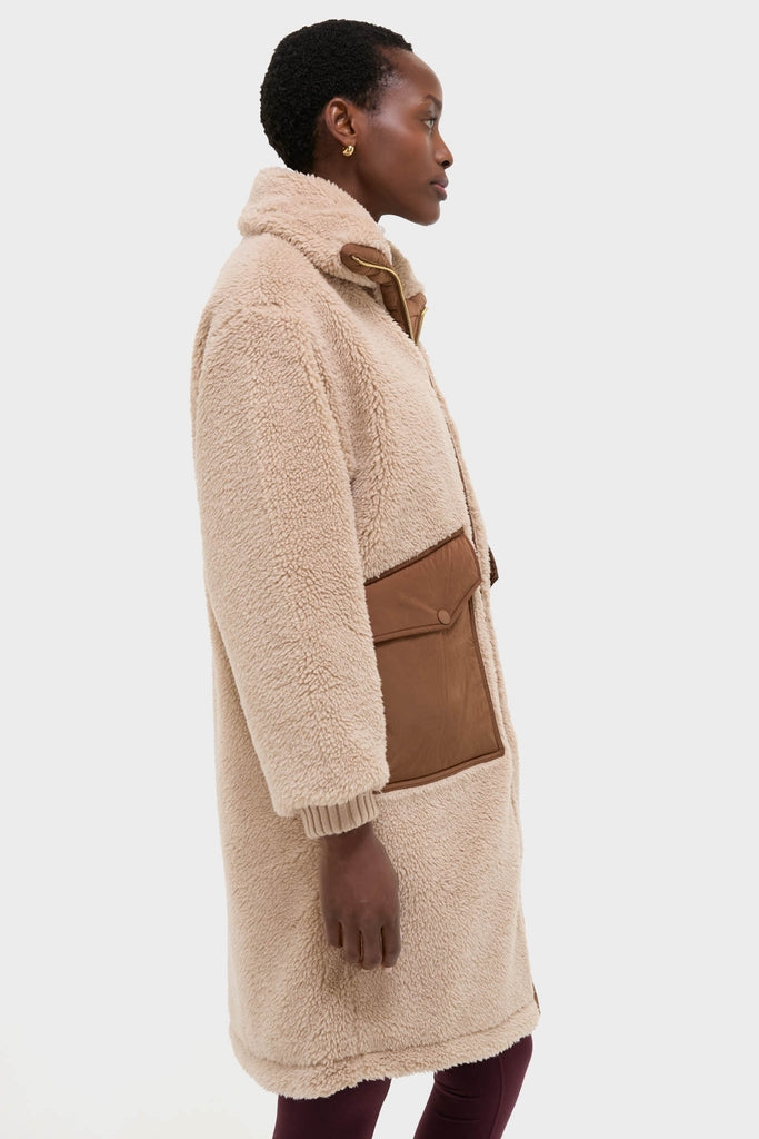 Model wearing the classic Light Taupe and Cocoa Dust Theia Reversible Coat with sherpa exterior, oversized collar, rib-knit cuffs, and a large side pocket, exuding effortless, high-end style.