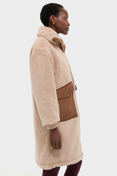 Model wearing the classic Light Taupe and Cocoa Dust Theia Reversible Coat with sherpa exterior, oversized collar, rib-knit cuffs, and a large side pocket, exuding effortless, high-end style.