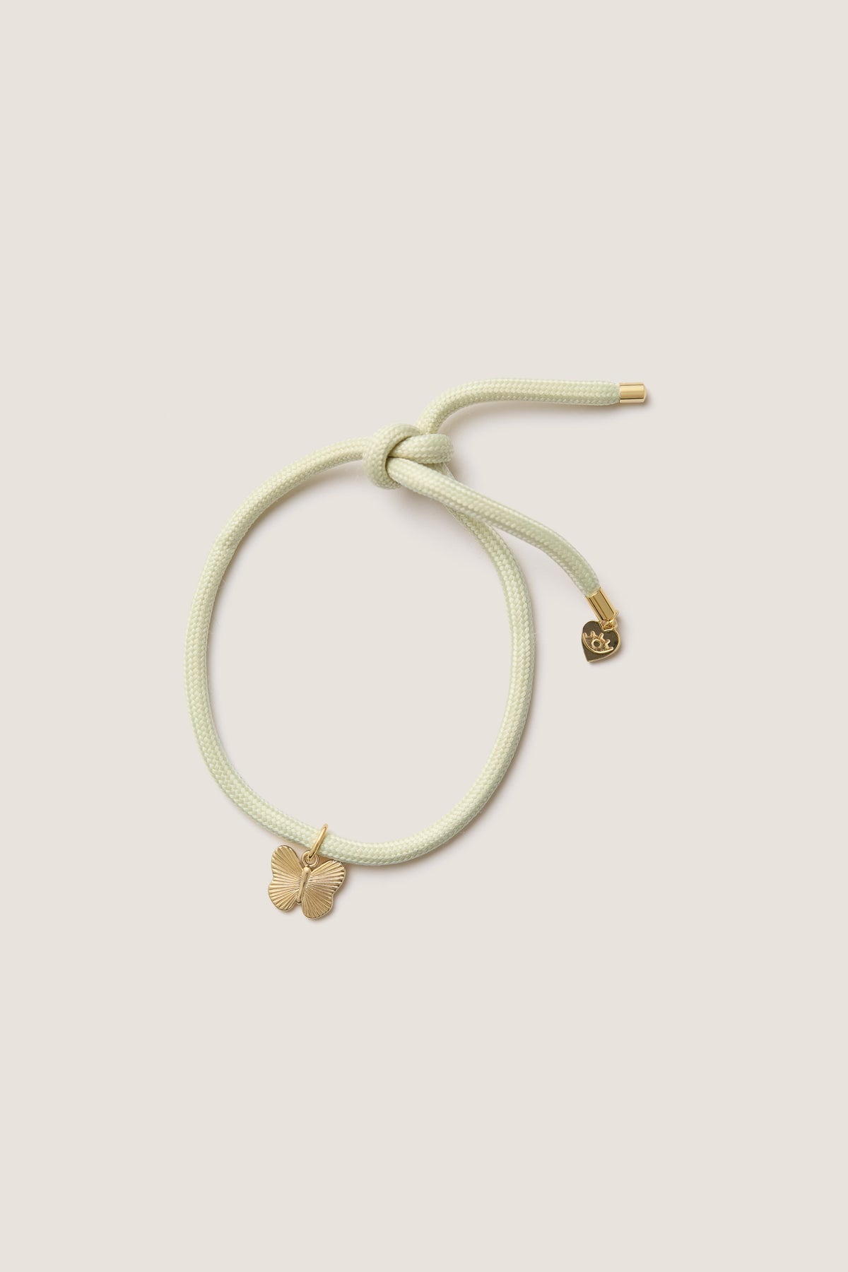 Vineyard Bracelet Cord with Butterfly Charm: A classic, effortless piece featuring a pastel cord with a gold butterfly and heart charm, perfect for fun, high-end wrist styling.