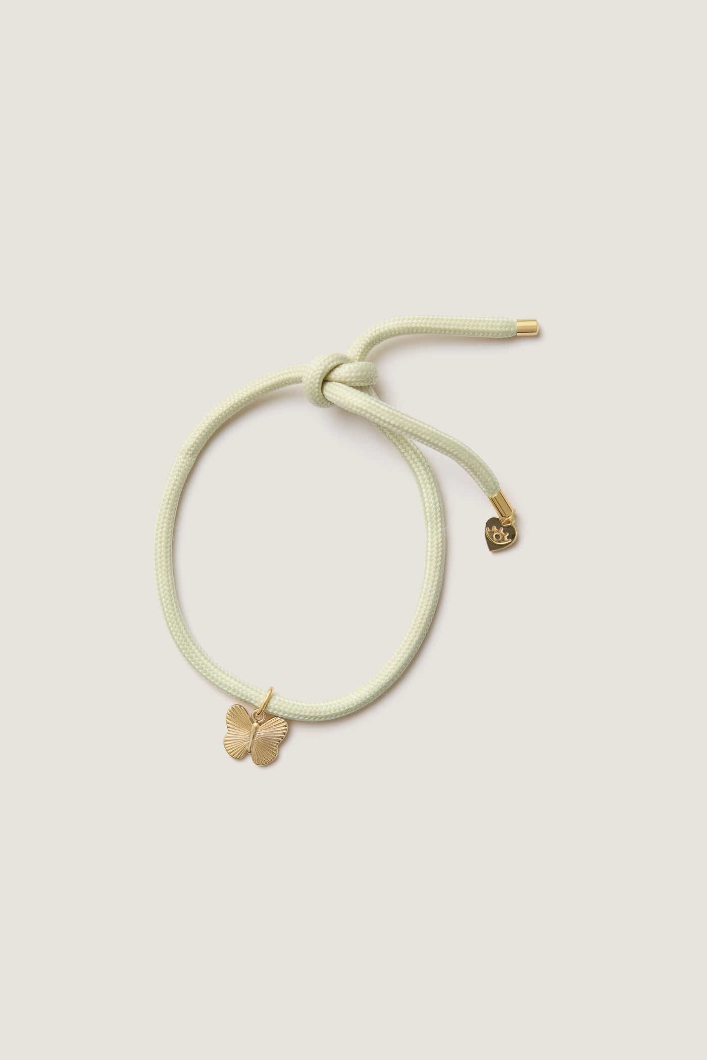 Vineyard Bracelet Cord with Butterfly Charm: A classic, effortless piece featuring a pastel cord with a gold butterfly and heart charm, perfect for fun, high-end wrist styling.