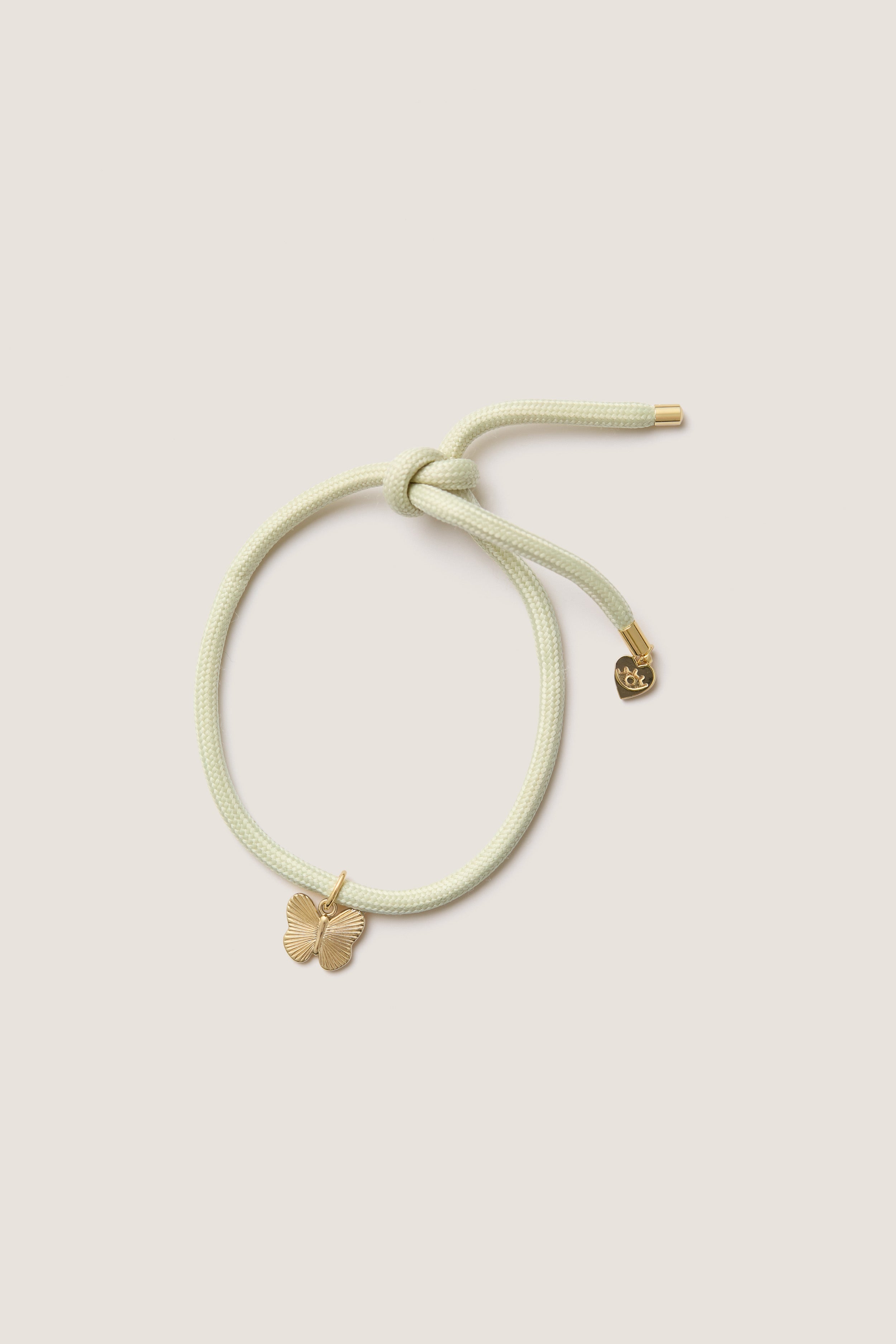Vineyard Bracelet Cord with Butterfly Charm: A classic, effortless piece featuring a pastel cord with a gold butterfly and heart charm, perfect for fun, high-end wrist styling.