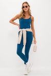 Woman in classic Harbor Blue Compression Spandex Sofia Cami with adjustable straps, effortlessly paired with leggings, sneakers, and accessories, showcasing a fun, high-end athletic style.