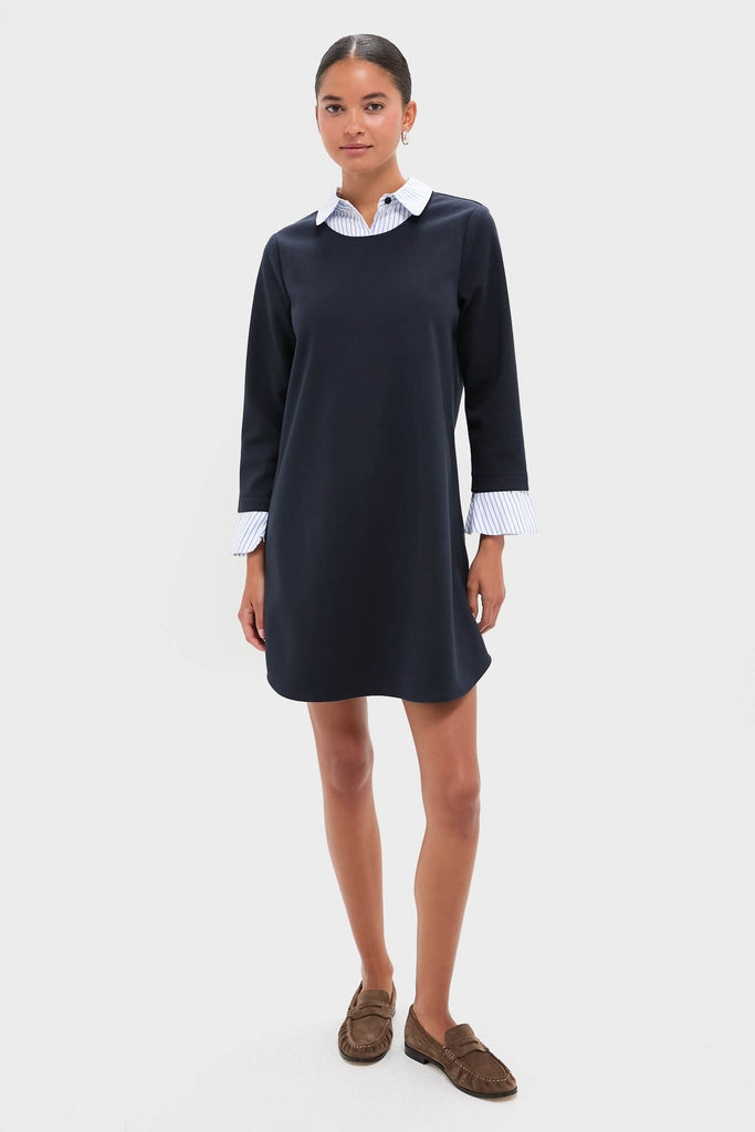 Model wearing Navy Knit Long Sleeve Burbank Mini Dress with layered effect, showcasing classic collared neckline and flared cuffs, styled with brown suede loafers for an effortless, high-end look.
