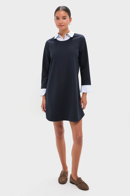 Model wearing Navy Knit Long Sleeve Burbank Mini Dress with layered effect, showcasing classic collared neckline and flared cuffs, styled with brown suede loafers for an effortless, high-end look.