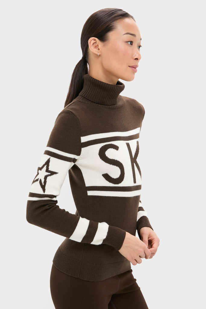 Model in profile wearing the Chocolate Schild Sweater: a classic, high-end Merino wool turtleneck with SK and star motif, showcasing effortless, fun style.