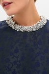 Close-up of a woman's lower face and neck, showcasing the classic Midnight Alison Short Sleeve Mini Dress, paired with an effortless, high-end pearl and crystal necklace.