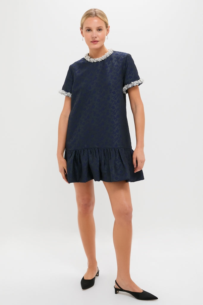 Woman wearing the classic Midnight Alison Short Sleeve Mini Dress, featuring a fun jacquard pattern, effortless drop-waist silhouette, and high-end textured fringe detailing.