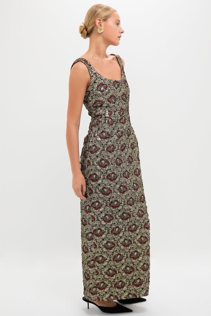 Model in a side-profile wearing the Ruby Multi Ravenna Midi Dress, a classic, sleeveless evening gown with a metallic gold and burgundy floral motif, paired with black heels.