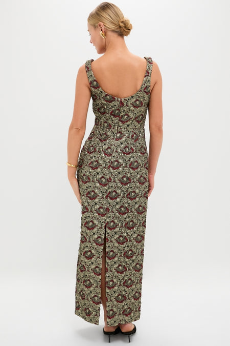 Woman in Ruby Multi Ravenna Midi Dress, featuring an effortless, high-end metallic jacquard fabric with a classic scoop back, fitted waist, and ornate gold-burgundy floral pattern.