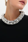Woman wearing Black Ozelle Short Sleeve Crewneck Top with a high-end, beaded collar trim featuring pearls and crystals, paired with a dangling pearl earring for an effortless, classic look.