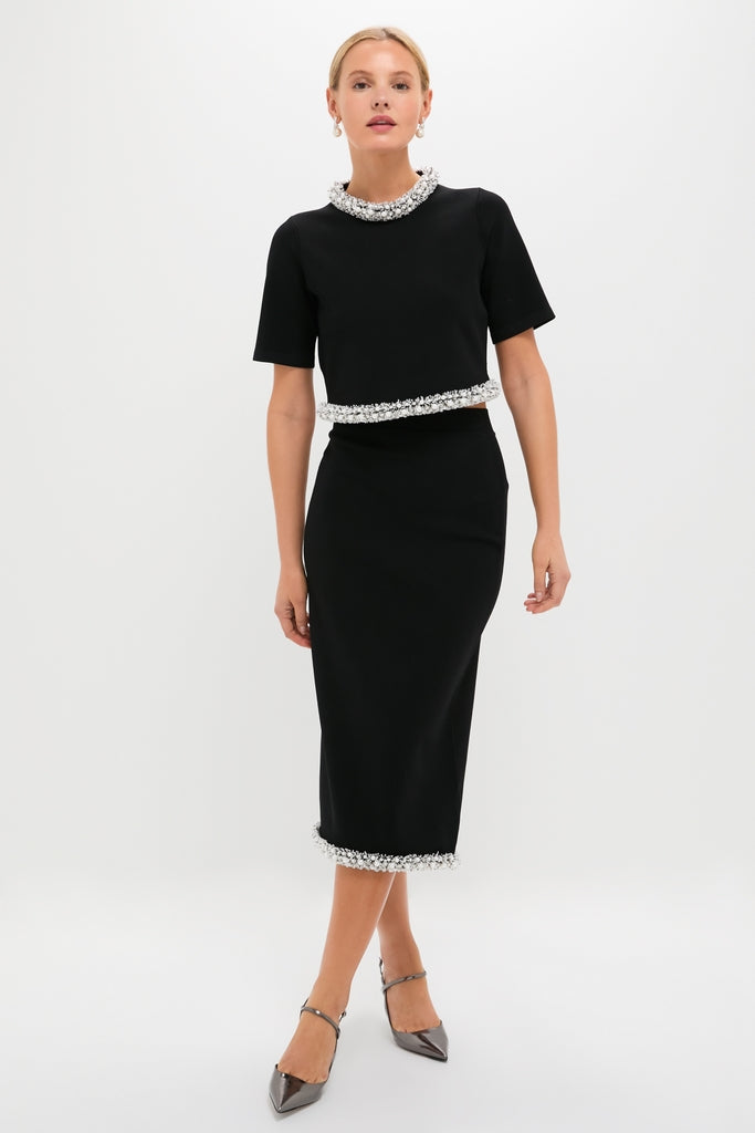 Model wearing the Black Ozelle Short Sleeve Crewneck Top with matching pencil skirt, featuring classic textured trim. Effortless and high-end, paired with strappy heels for a fun, sleek look.