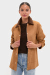 Young woman wearing the Chestnut Faux Suede Cody Jacket with metal snap buttons and a zip front, paired with light blue jeans, embodying a classic and effortless style.