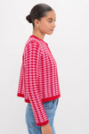 Woman in profile wearing the Pink & Red Knit Cassie Cardigan, showcasing a classic, effortless style paired with blue denim jeans, embodying Tuckernuck's fun, high-end fashion ethos.