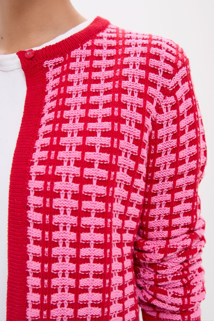 Pink & Red Knit Cassie Cardigan featuring a classic raised grid pattern, worn effortlessly over a white T-shirt, embodying fun and high-end style.